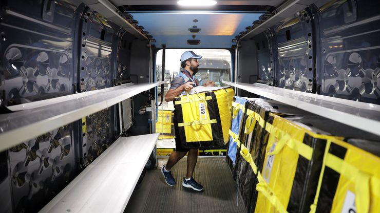 Delivery associate Ali Haider loads totes into his Electronic Delivery Vehicle (EDV) at one...