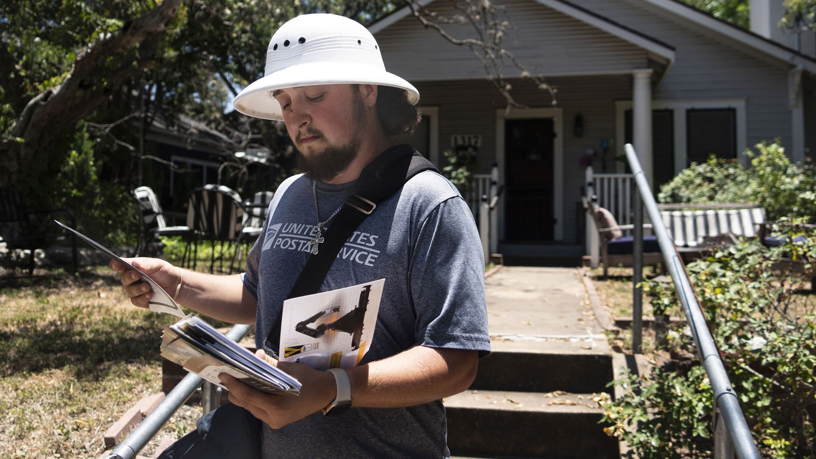 Mailman Rhett Hanes wears a safety hat to protect from hawk attacks while delivering mail on...